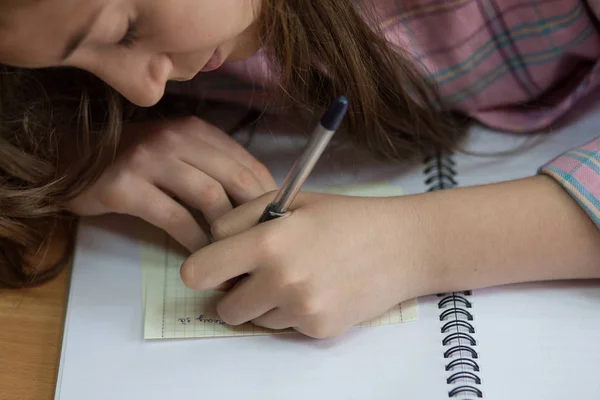 Kleines Mädchen Schreibt Etwas Ins Textbuch Und Sitzt Tisch — Stockfoto