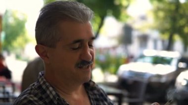 Kameraya bakarak ve gülümseyen Gözlüklü olgun, çekici bir adam portresi.
