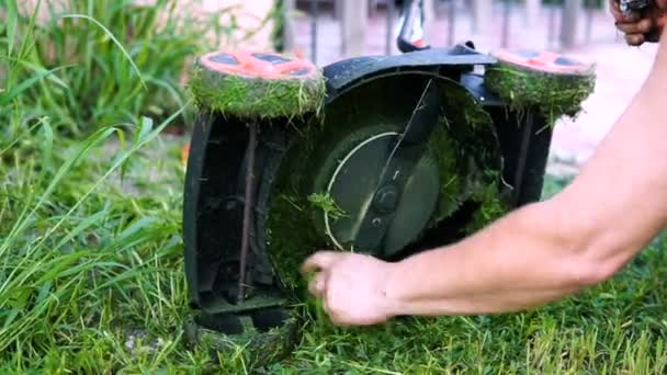 Pracovník vyčistí sekačku na trávu — Stock video