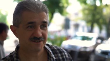 Kameraya bakarak ve gülümseyen Gözlüklü olgun, çekici bir adam portresi.