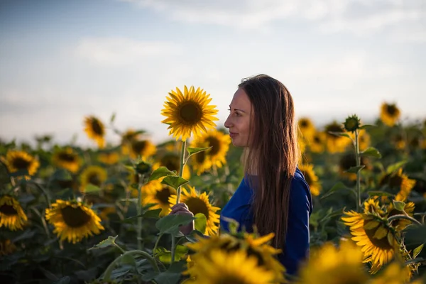 Chica en un vestido azul en el campo de los girasoles —  Fotos de Stock