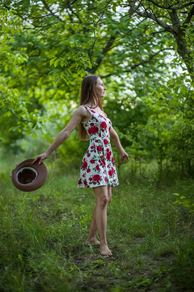 Симпатичная молодая женщина прыгает по зеленому парку — стоковое фото