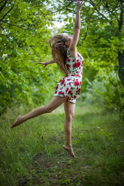 Bonita jovem mulher pulando no parque verde — Fotografia de Stock