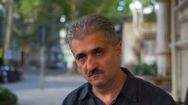 Yakışıklı adam kameraya açık konuşuyor kafede, steadycam atış oturmuş