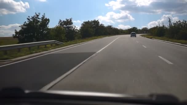 汽车正沿着公路行驶 沥青路在农业领域和驾驶的汽车之间 前视图 — 图库视频影像