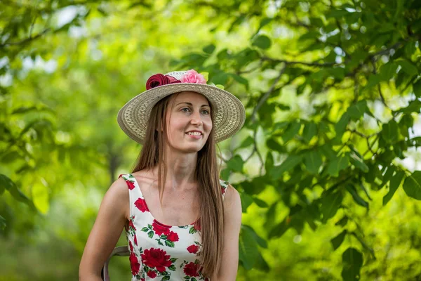 一个美丽优雅的女人在白色的礼服和帽子站在夏季公园的肖像 — 图库照片