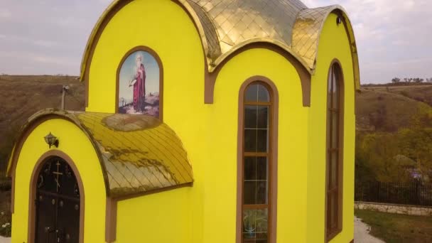 空中ドローンは モルドバの田舎の村で小さな黄色い教会を撮影しました ヨーロッパ — ストック動画