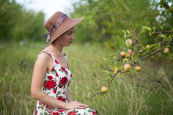 美丽的女孩站在苹果园的背景上 这个女孩穿着一件夏装 — 图库照片