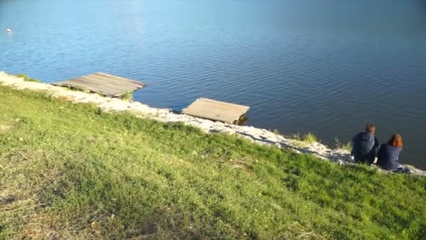 Mladý Pár Posezení Přijímání Lake Shore Při Pohledu Vodní Vlny — Stock video