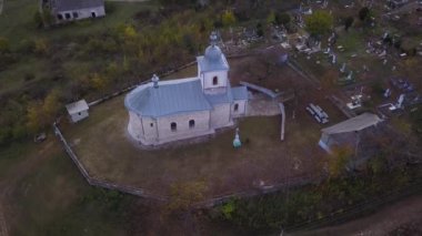 Kamera, Moldova Cumhuriyeti 'ndeki Ortodoks Kilisesi ve küçük bir köy üzerinde uçuyor..
