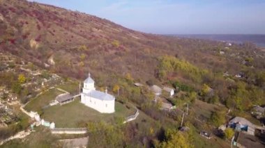 Kamera, Moldova Cumhuriyeti 'ndeki Ortodoks Kilisesi ve küçük bir köy üzerinde uçuyor..