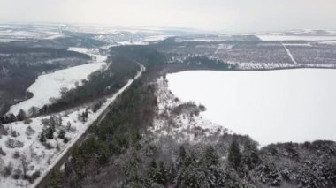 Gökyüzü insansız hava aracıyla cennet kışı manzarası. Kuşların gözünden doğaya doğru koşan bir sokak..