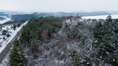 Gökyüzü insansız hava aracıyla cennet kışı manzarası. Kuşların gözünden doğaya doğru koşan bir sokak..