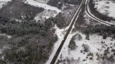 Gökyüzü insansız hava aracıyla cennet kışı manzarası. Kuşların gözünden doğaya doğru koşan bir sokak.