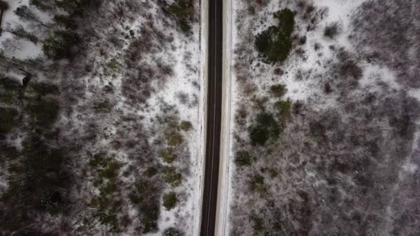 Vue aérienne par drone de la route dans un paysage hivernal idyllique. Rue traversant la nature depuis une vue d'oiseau