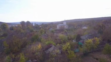 Kamera, Moldova Cumhuriyeti 'ndeki Ortodoks Kilisesi ve küçük bir köy üzerinde uçuyor..