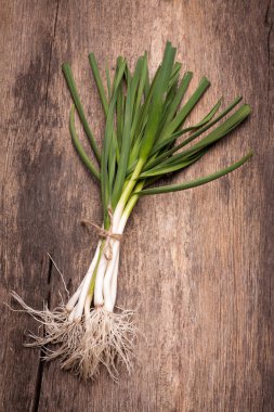 Eski ahşap bir masa üzerinde genç sarımsak. Rustik tarzı.