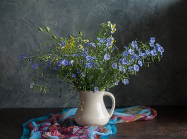 Kır çiçekleri ile natürmort. mavi bir vazoda kır çiçekleri. Rustik stile.