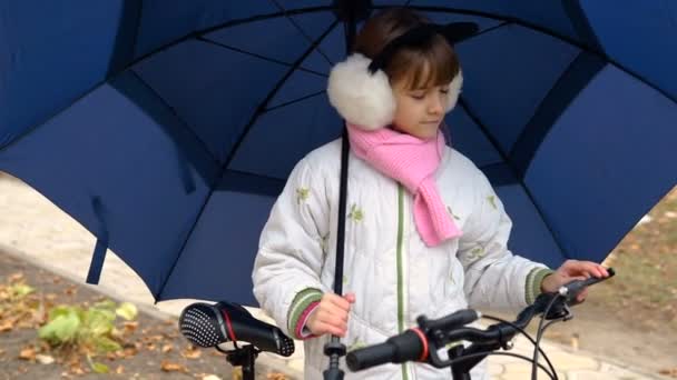 明るいオープン傘をねじるきれいな笑顔の若い女の子の肖像画を間近します — ストック動画