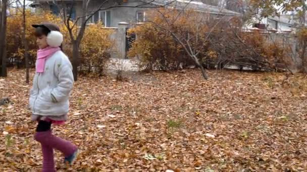 une petite fille se promène dans le parc à l'automne 