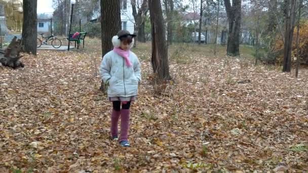 une petite fille se promène dans le parc à l'automne 