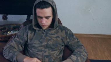 Evde dizüstü bilgisayarla çalışan genç bir adam. Uzaktan çalışma, serbest çalışma