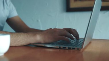 Onun laptop tuş takımında yazarak bir adam el closeup çekim. Adam evde bilgisayar üzerinde çalışıyor. Laptop tuş takımında yazarak üzerinde odaklanmak.