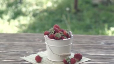 Bahçedeki ahşap masa üzerinde uyumak kase taze çilek