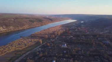 Arial manzara nehir ve gün batımında küçük bir köy. Dniester Nehri Moldova Cumhuriyeti.
