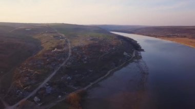 Arial manzara nehir ve gün batımında küçük bir köy. Dniester Nehri Moldova Cumhuriyeti.