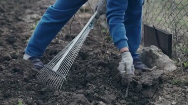 Bahçedeki kahverengi toprak seviyesine bir komisyon kullanarak kadın çiftçi