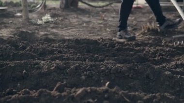 Bahçedeki kahverengi toprak seviyesine bir komisyon kullanarak erkek çiftçi