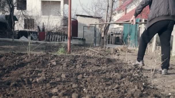 Αρσενικό Αγρότης Χρησιμοποιώντας Μια Τσουγκράνα Επίπεδο Καφέ Χώμα Στον Κήπο — Αρχείο Βίντεο