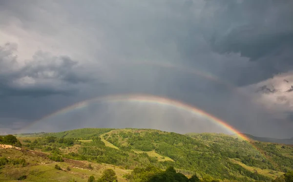 Belle vallée de montagne avec collines verdoyantes et immense arc-en-ciel — Photo