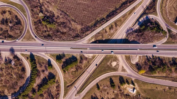 Aerial top down view of interchange road junction traffic. Drone shot flying over crossing roads and railway track. Moldova republic of.