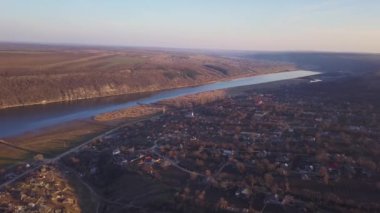 Arial manzara nehir ve gün batımında küçük bir köy. Dniester Nehri Moldova Cumhuriyeti.