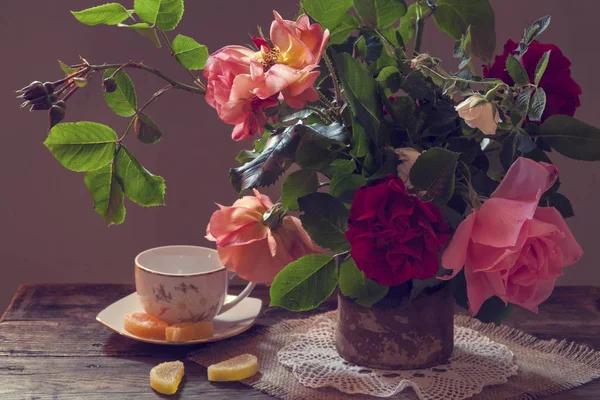 木制桌子上花瓶里的红玫瑰 — 图库照片