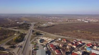 Sinematik havadan görüntüleri. Köy yolu. Araba ile ağaçlar ve ev ve alanlar yolda gidiyor. 4k.