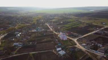 Gün batımında merkezinde bir kilise ile küçük bir köy üzerinde uçuş. Avrupa Köyü.
