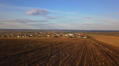 Sunset light over cultivating field and small village in the spring. Moldova Republic of.