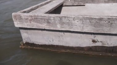 Rıhtımiskelesindeki eski bir tekne yakın çekimde. Eski demir yıpranmış ve eski tekne burunları ahşap rıhtım yakın çekim bağlı.