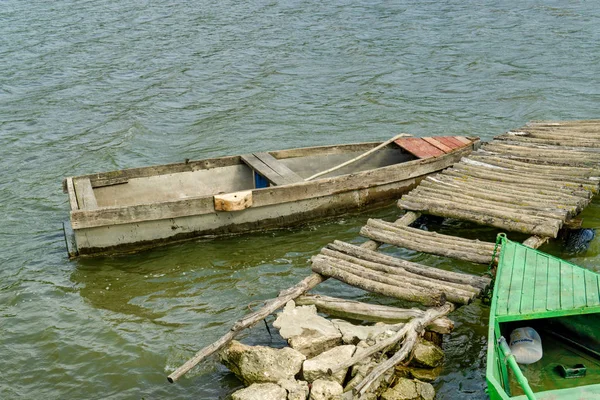 Velho barco de pesca de remo de madeira atracado perto do lago ou da costa do rio em belo dia ensolarado — Fotografia de Stock