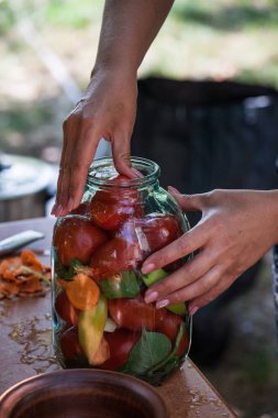 cam kavanozda korunmuş sebze hazırlayan kadın