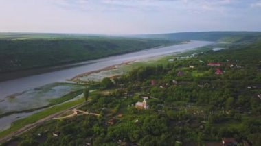 Güneşli bir yaz gününde nehir ve küçük bir köy üzerinde uçan. Moldova Cumhuriyeti'nin Dinyester Nehri.