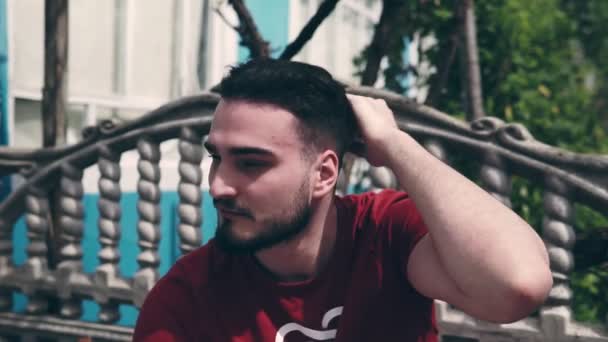 Sakallı Genç Bir Adam Kameraya Bakar Duygusal Bir Şey Söyler — Stok video
