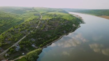Güneşli bir yaz gününde nehir ve küçük bir köy üzerinde uçan. Moldova Cumhuriyeti'nin Dinyester Nehri.