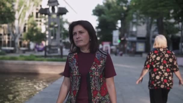 都市の夏の公園を歩く若いブルネットの女性 — ストック動画