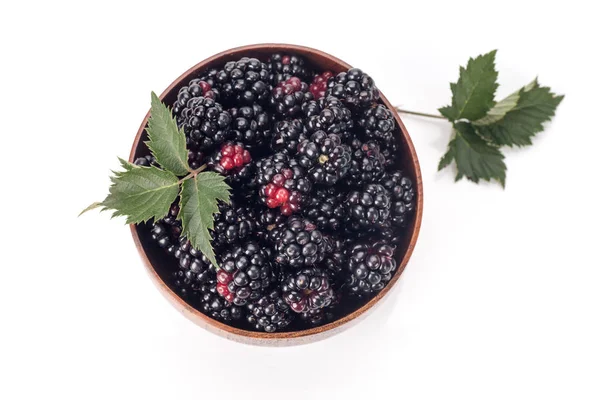 Чернослив в деревянном банте. Спелые и вкусные черные ягоды изолированы на белом. Blackberries на белом фоне. Вид сверху . — стоковое фото