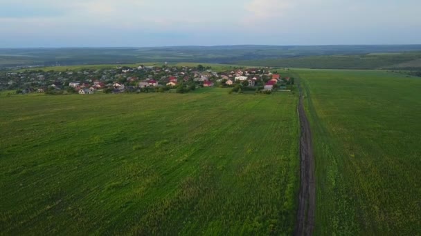 飞过绿色的乡村丘陵和村庄的房屋 春天的农田 无人机视图 — 图库视频影像