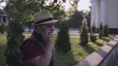 Güzel kadın şehir parkında bankta oturur ve cep telefonu yla konuşur. Çekici kız cep telefonuyla konuşuyor. Beyaz akıllı telefonu olan kadın. akıllı telefon ile kadın kamu bahçesinde oturur